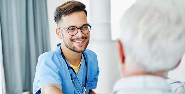 Krankenpfleger lächelt einen Patienten an