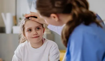 Kleines Mädchen im Krankenbett und Pflegerin